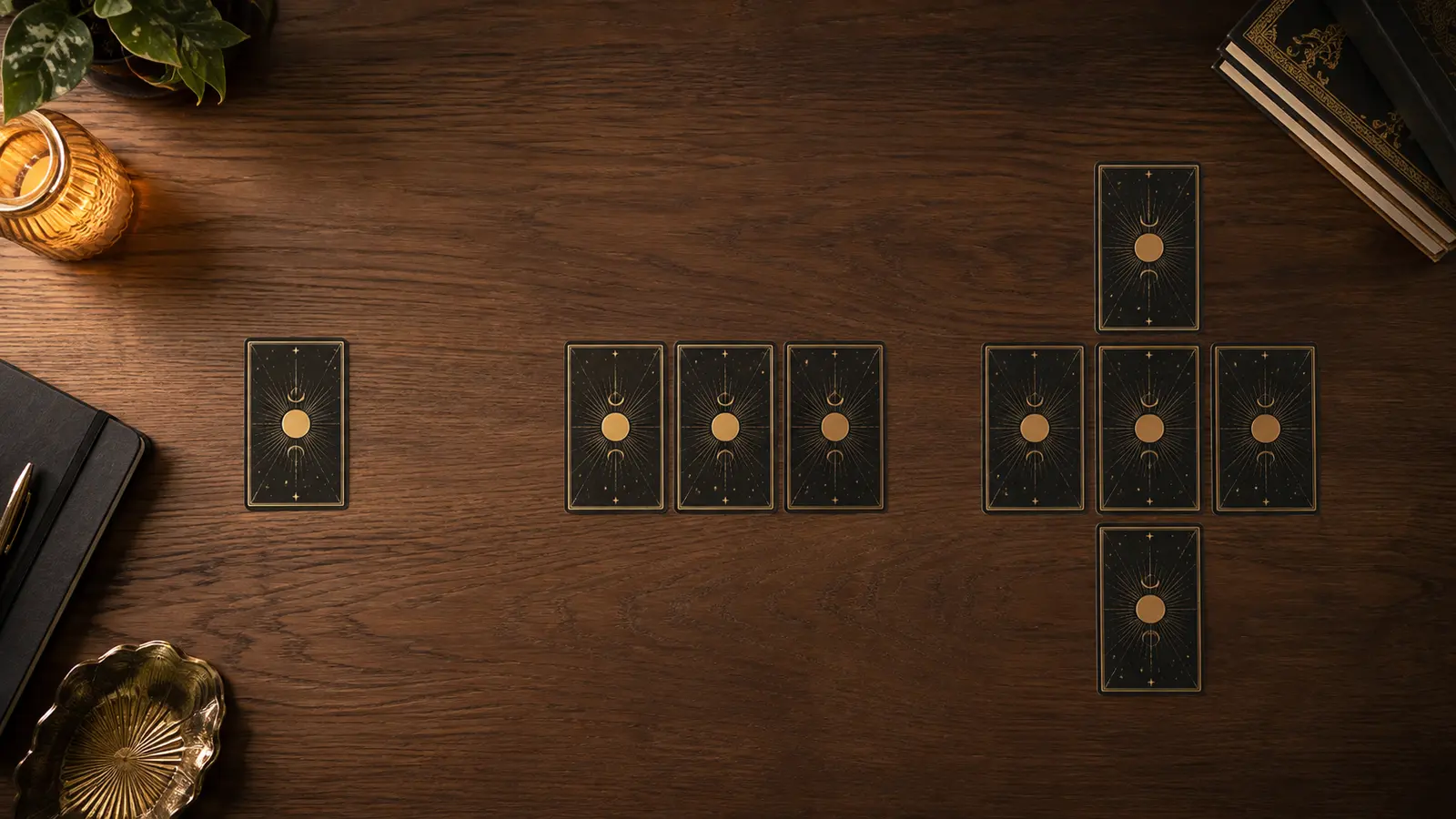 Vista aérea de tres tiradas distintas de cartas de tarot boca abajo sobre una mesa de madera